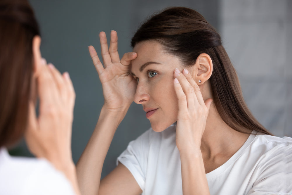 a women looking  in rh mirror checking her fascial skin after taking zenutri vitamins