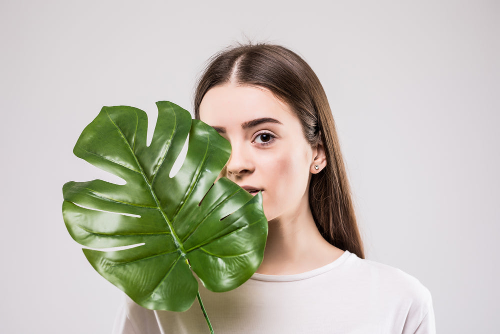 female holding a green leaf  , illustrating the wellness after using zenutri vitamin
